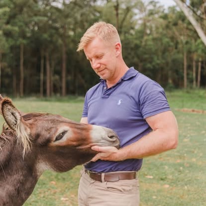 The owner with a donkey at Little Donkey Estate